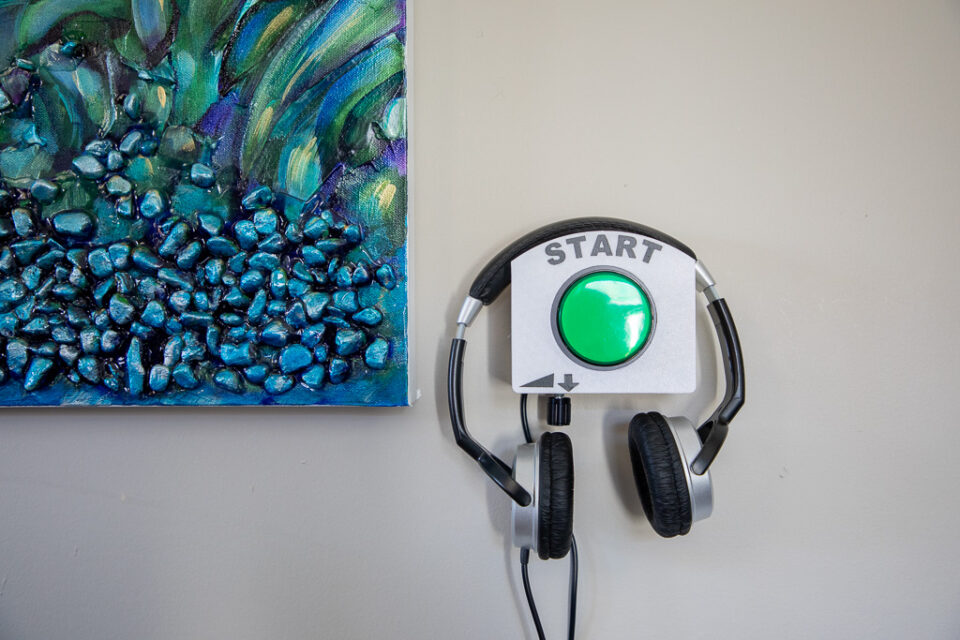 An audio player on a wall beside a painting
