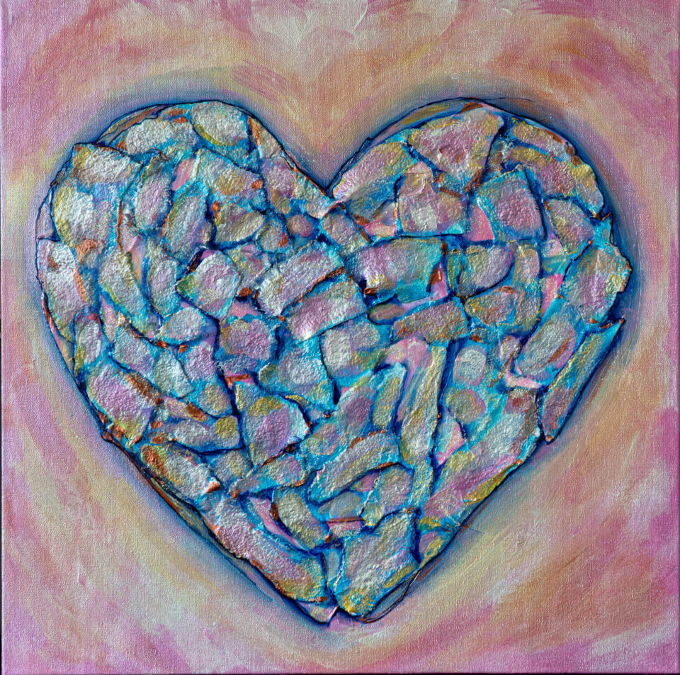 A blue heart filled with shiny, irregular shapes in vaious shades of blue, pink and pearl surrounded by a pink and gold background.