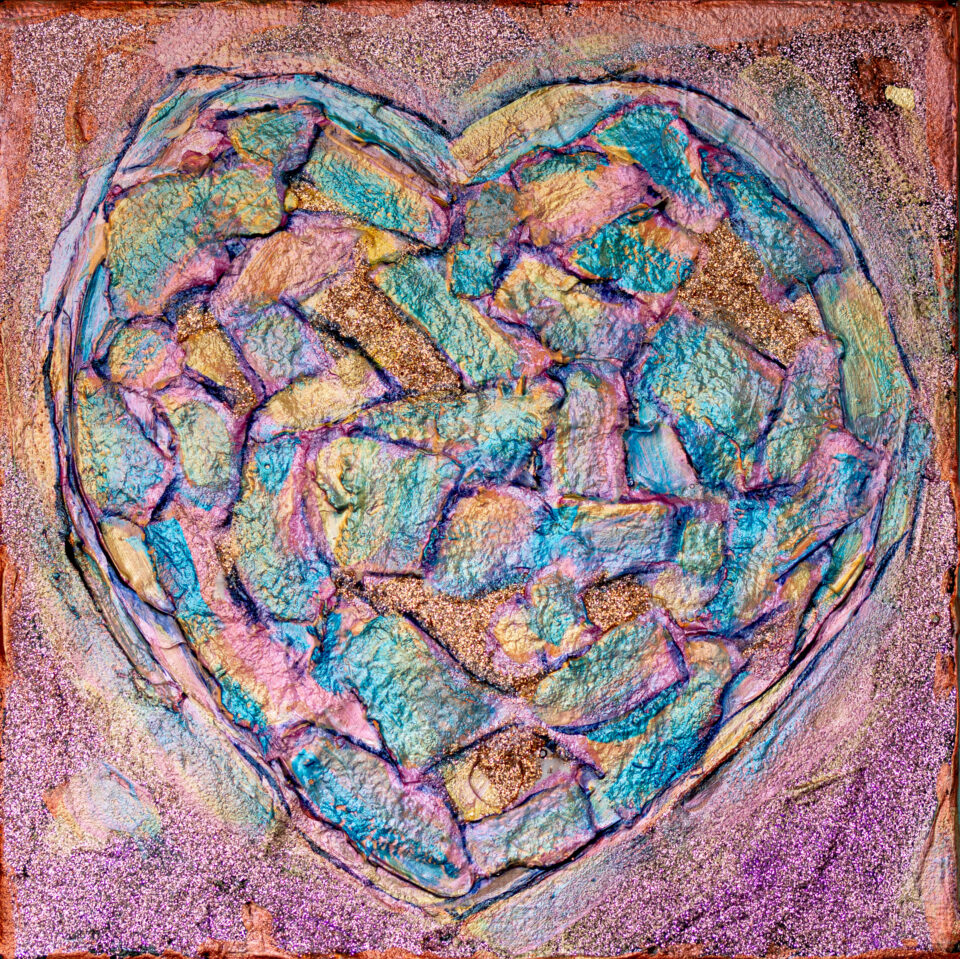 A luminescent blue, pink, and gold heart on a light pink background.