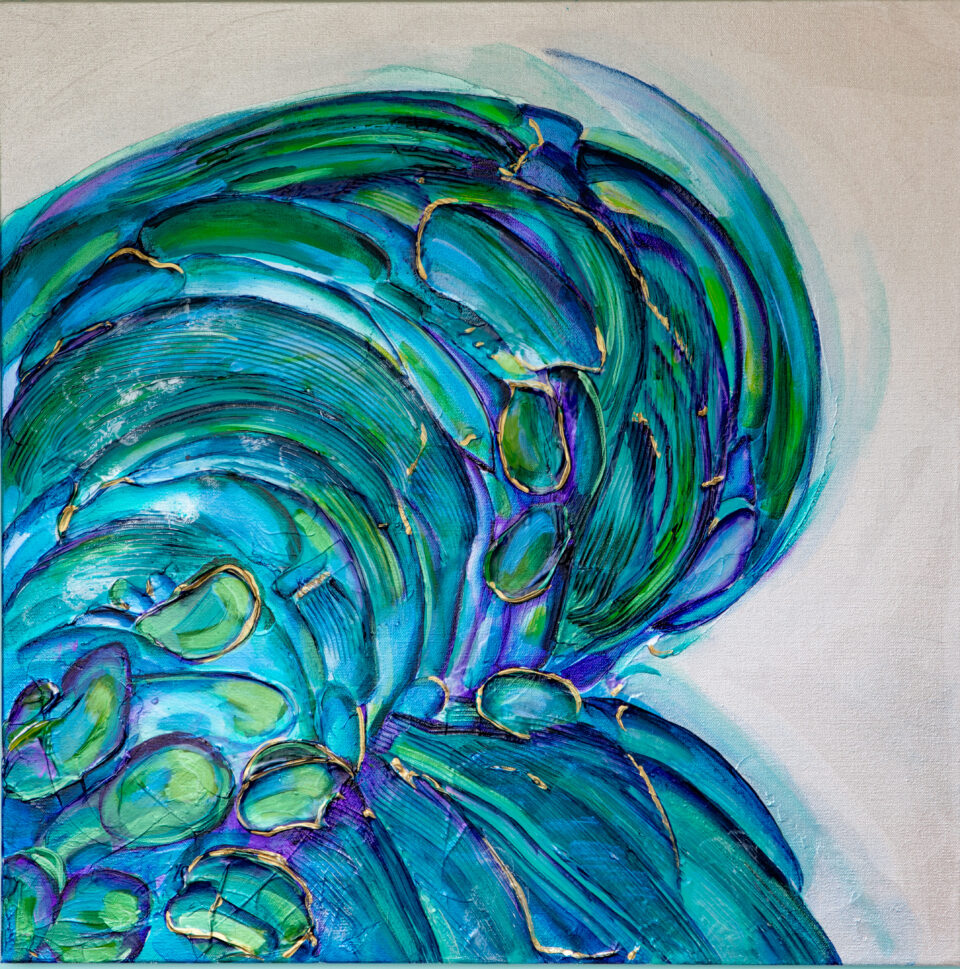 A blue and green heart lies in its side on a pearly white background.