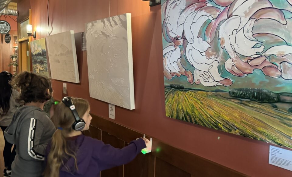 A young patron listens to an audio description